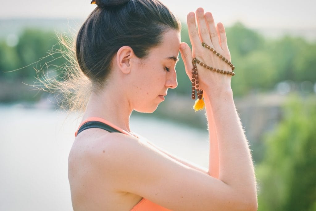 Spiritual Awakening, A woman holding a mala praying
